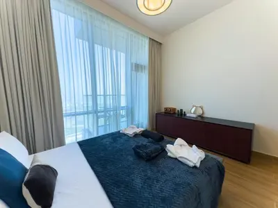 a bedroom with a large bed with a large window at Modern and Spacious 2BR in Business Bay in Dubai