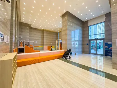 a lobby with an orange couch in a building at Modern and Spacious 2BR in Business Bay in Dubai