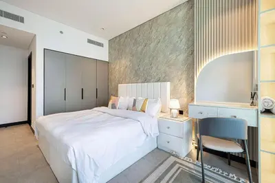 a bedroom with a large white bed and a chair at DVR 2BR in 15 Northside Business bay in Dubai