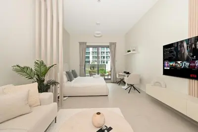 a white living room with a couch and a tv at Brand New Luxury Stays by Edora at Sway Residence Dubai Hills in Dubai