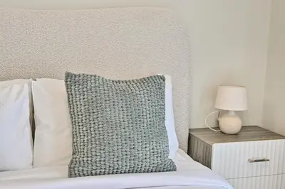 a bed with a pillow and a lamp on a night stand at Brand New Luxury Stays by Edora at Sway Residence Dubai Hills in Dubai