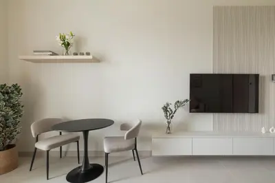 a living room with a table and chairs and a tv at Brand New Luxury Stays by Edora at Sway Residence Dubai Hills in Dubai