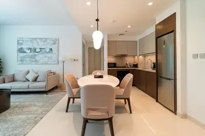 a kitchen and living room with a table and chairs at Golden Coast Stay in Dubai
