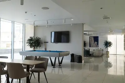 a room with a ping pong table and chairs at Golden Coast Stay in Dubai
