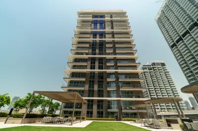 a tall apartment building in the middle of two tall buildings at Golden Coast Stay in Dubai