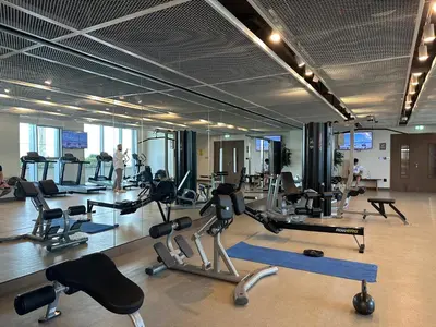 a gym with lots of exercise equipment and people in it at Golden Coast Stay in Dubai