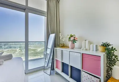 a room with a dresser and a large window at Carson Tower B,Damac Hills - Studio Apartment - Allsopp & Allsopp in Dubai