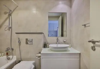 a bathroom with a sink and a mirror at Carson Tower B,Damac Hills - Studio Apartment - Allsopp & Allsopp in Dubai