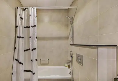 a bathroom with a shower with a shower curtain at Carson Tower B,Damac Hills - Studio Apartment - Allsopp & Allsopp in Dubai