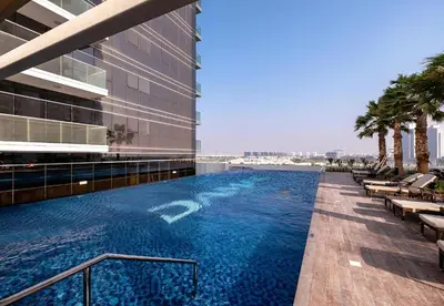 a swimming pool on the side of a building at Carson Tower B,Damac Hills - Studio Apartment - Allsopp & Allsopp in Dubai