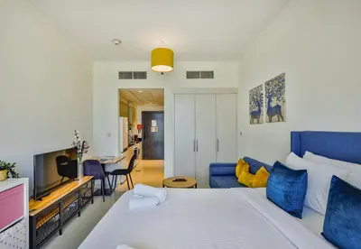 a bedroom with a bed and a living room at Carson Tower B,Damac Hills - Studio Apartment - Allsopp & Allsopp in Dubai