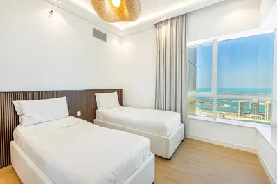 a hotel room with two beds and a window at Daniels 3BR with Palm View at Marina Pinnacle in Dubai