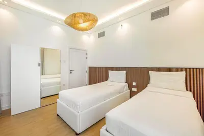 a bedroom with two beds and a mirror at Daniels 3BR with Palm View at Marina Pinnacle in Dubai