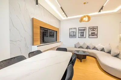 a living room with a couch and a tv at Daniels 3BR with Palm View at Marina Pinnacle in Dubai