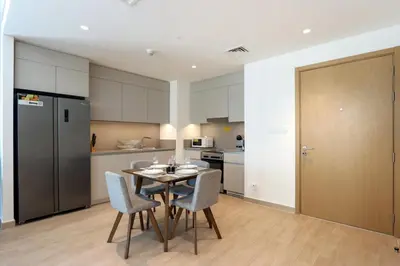 a kitchen and dining room with a table and chairs at Livbnb-Elegant 2BR, Creek Beach, Pool & Gym in Dubai