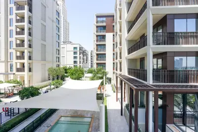 an aerial view of an apartment building with a swimming pool at Livbnb-Elegant 2BR, Creek Beach, Pool & Gym in Dubai