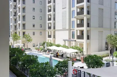 an image of an apartment complex with a swimming pool at Livbnb-Elegant 2BR, Creek Beach, Pool & Gym in Dubai
