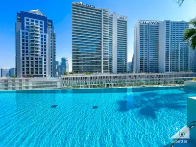 a large swimming pool in front of some tall buildings at Luxury at Sterling East Studio with Park Views in Dubai
