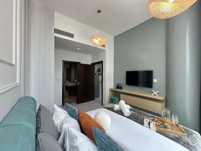 a living room with a couch and a tv at Sunsets and Skylines 1BR in Panoramic Tower in Dubai