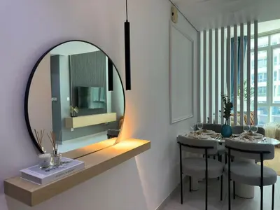 a room with a mirror and a table with chairs at Sunsets and Skylines 1BR in Panoramic Tower in Dubai
