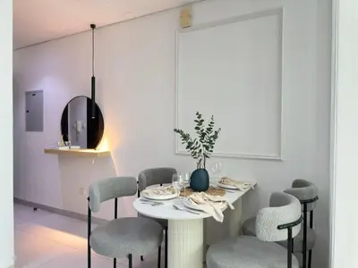 a dining room with a white table and chairs at Sunsets and Skylines 1BR in Panoramic Tower in Dubai