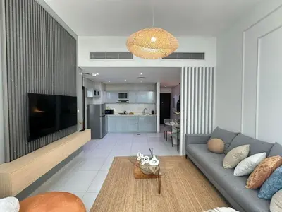 a living room with a couch and a television at Sunsets and Skylines 1BR in Panoramic Tower in Dubai