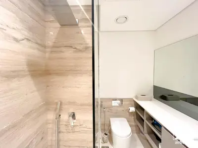 a bathroom with a glass shower and a toilet at Streling Studio with Balcony & City Views in Dubai