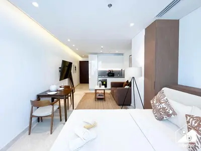 a bedroom with a bed and a dining room at Streling Studio with Balcony & City Views in Dubai