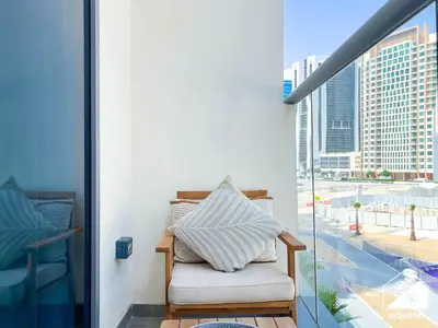 a chair on a balcony with a view of a city at Streling Studio with Balcony & City Views in Dubai
