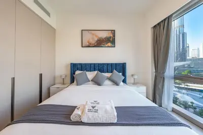 a bedroom with a large bed with a window at Luxury Stay with Burj views in Dubai