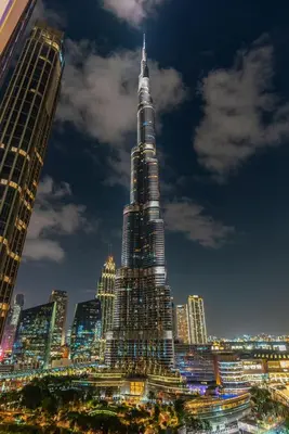 a tall skyscraper in a city at night at Luxury Stay with Burj views in Dubai