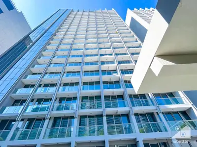 a tall building with blue windows in a city at Sterling East Prime Location ST in Business Bay in Dubai