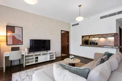 a living room with a couch and a tv at Exceptional 1-bedroom with pool view in Downtown in Dubai