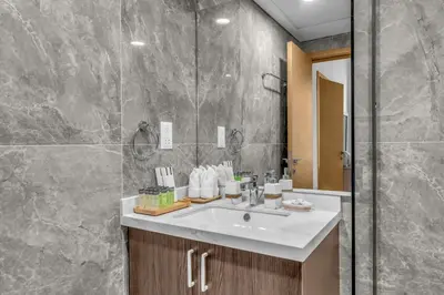 a bathroom with a white sink and a shower at Waves - Rustic Chic 1 BR Retreat in Vibrant JVC in Dubai
