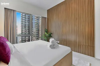 a bedroom with a white bed and a large window at bnbme - Luxury Downtown Dubai Apt Burj Khalifa Fountain Views Pool Gym Parking in Dubai