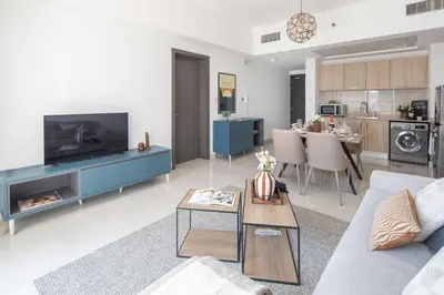a living room with a couch and a tv and a table at Frank Poretr - AG Tower in Dubai