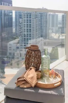 a tray with a bottle on a table with a window at Frank Poretr - AG Tower in Dubai