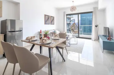 a kitchen and living room with a table and chairs at Frank Poretr - AG Tower in Dubai