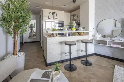 a kitchen with two bar stools and a counter at Frank Porter - Al Jawhara Tower in Dubai