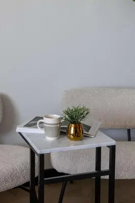 a table with a coffee cup and a plant on it at Frank Porter - Al Jawhara Tower in Dubai
