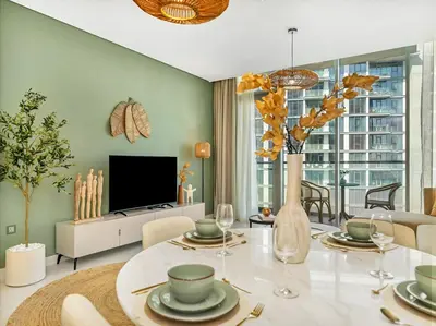 a living room with a table and a tv at Stunning Central 2BR Lagoon View & Private Beach in Dubai
