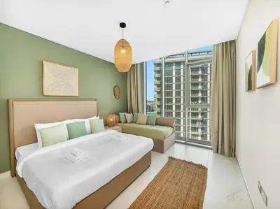 a bedroom with a large bed and a couch at Stunning Central 2BR Lagoon View & Private Beach in Dubai