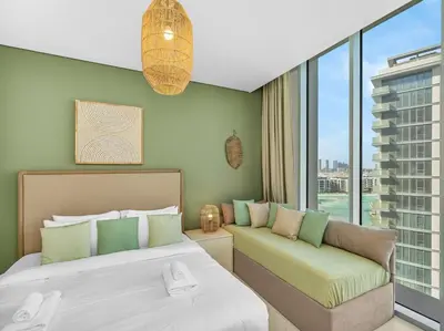 a bedroom with a large bed and a couch at Stunning Central 2BR Lagoon View & Private Beach in Dubai