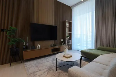 a living room with a couch and a flat screen tv at Gracious 1BR in Binghatti Amber in Dubai