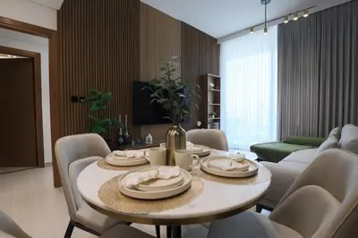 a living room with a table with chairs and a couch at Gracious 1BR in Binghatti Amber in Dubai