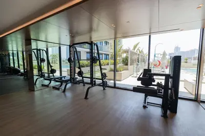 a gym with several tread machines in a building at Gracious 1BR in Binghatti Amber in Dubai