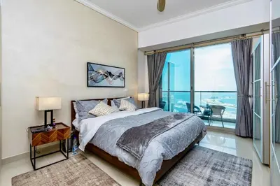 a bedroom with a bed and a large window at Ocean Heights Dubai Marina Ocean View in Dubai