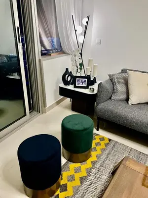 a living room with a couch and two stools and a table at Ocean Heights Dubai Marina Ocean View in Dubai