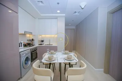 a kitchen with a table and chairs in a kitchen at Standard 1BHK located in Azizi Riviera 48 in Dubai