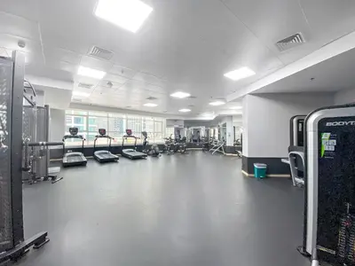 a gym with several people exercising on machines in a room at Bright Studio in Dubai Gate 2 in Dubai